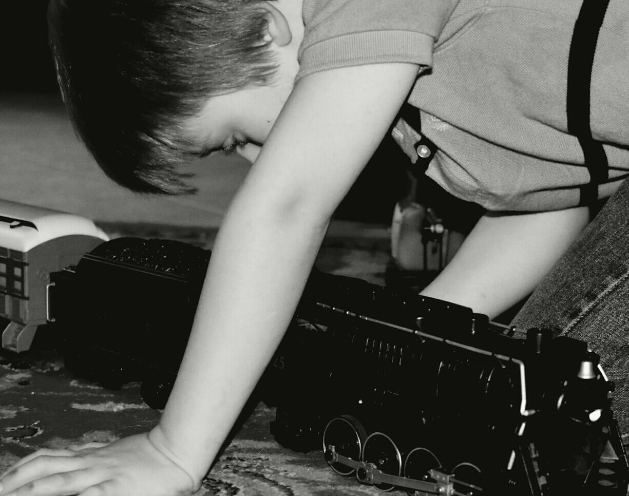 Boy playing with toy train at home