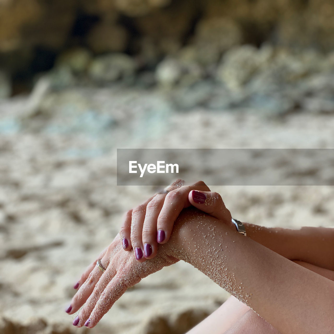 Cropped hand of woman on beach