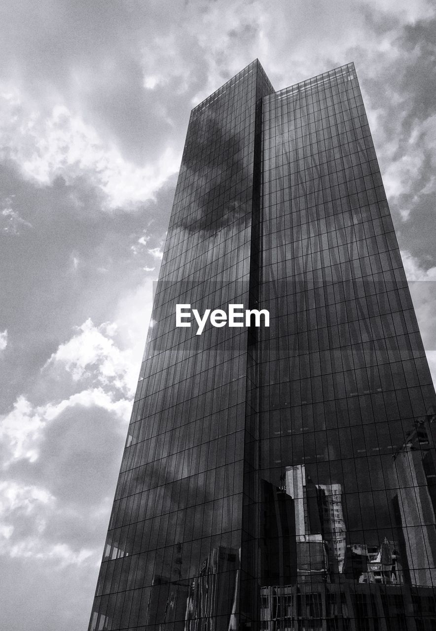 LOW ANGLE VIEW OF SKYSCRAPERS AGAINST CLOUDY SKY