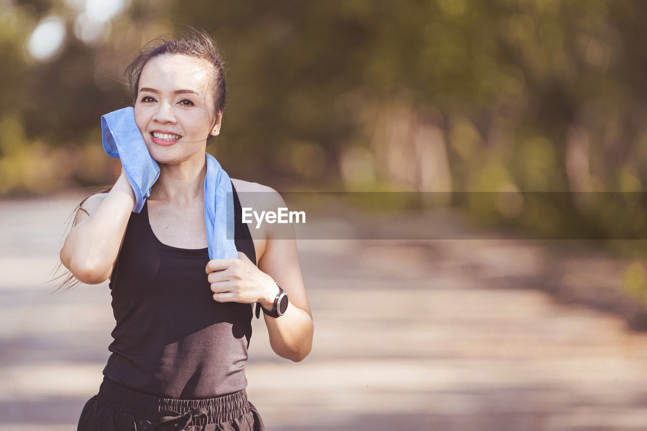 Portrait of smiling young woman standing outdoors