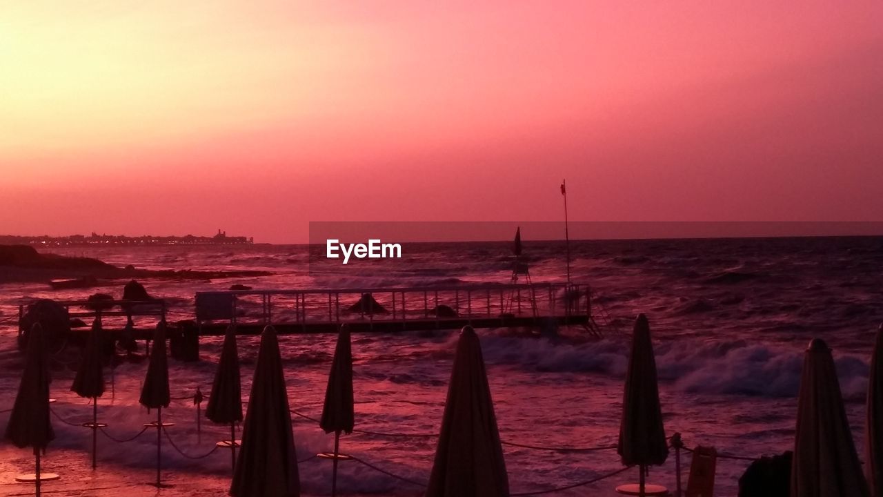 SCENIC VIEW OF BEACH AGAINST SKY DURING SUNSET