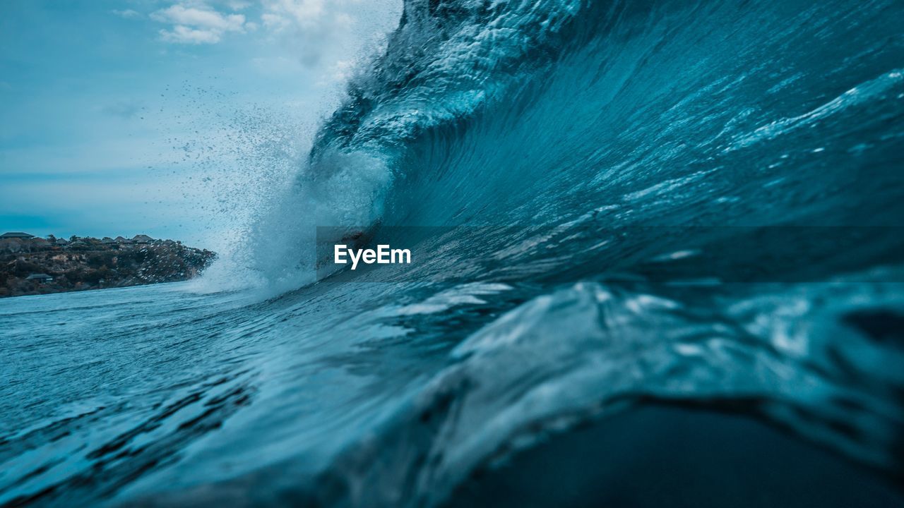 Sea waves splashing against blue sky