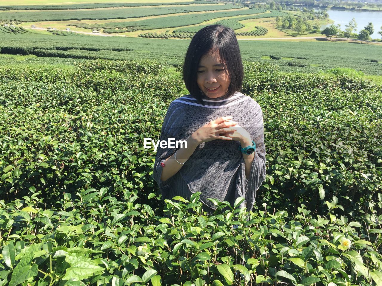 PORTRAIT OF SMILING YOUNG WOMAN ON FARM