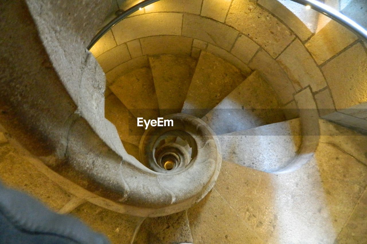 HIGH ANGLE VIEW OF SPIRAL STAIRS IN STAIRCASE