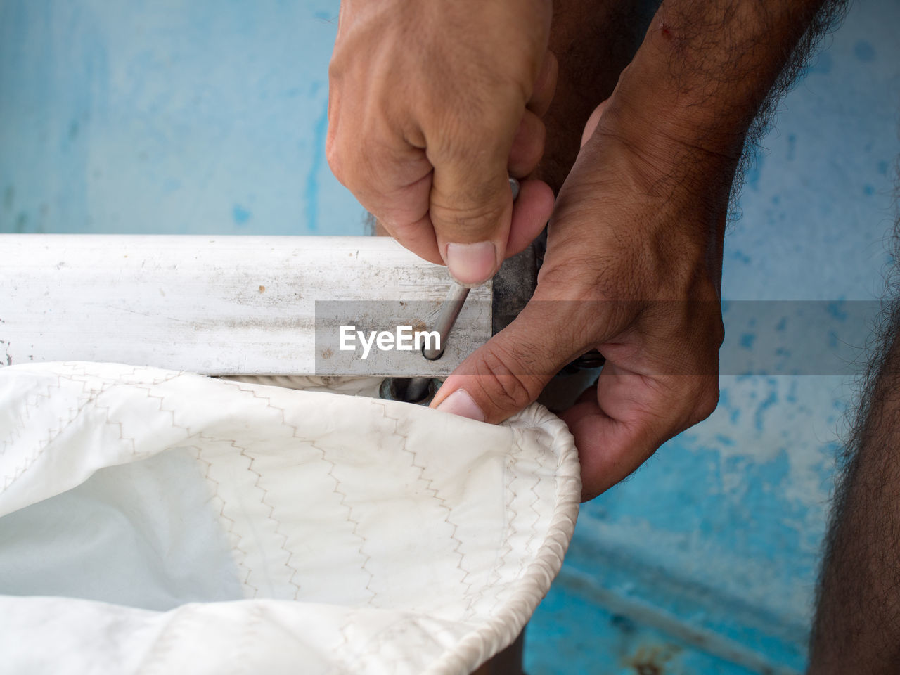 Close-up of hands fixing sail