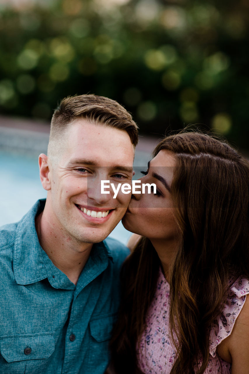 Wife kissing smiling husband on cheek in san diego