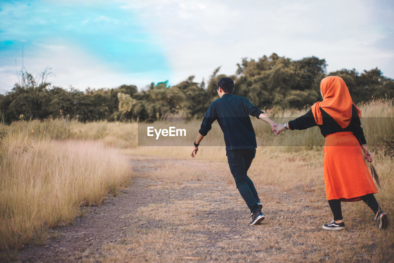 Rear view of couple walking on land