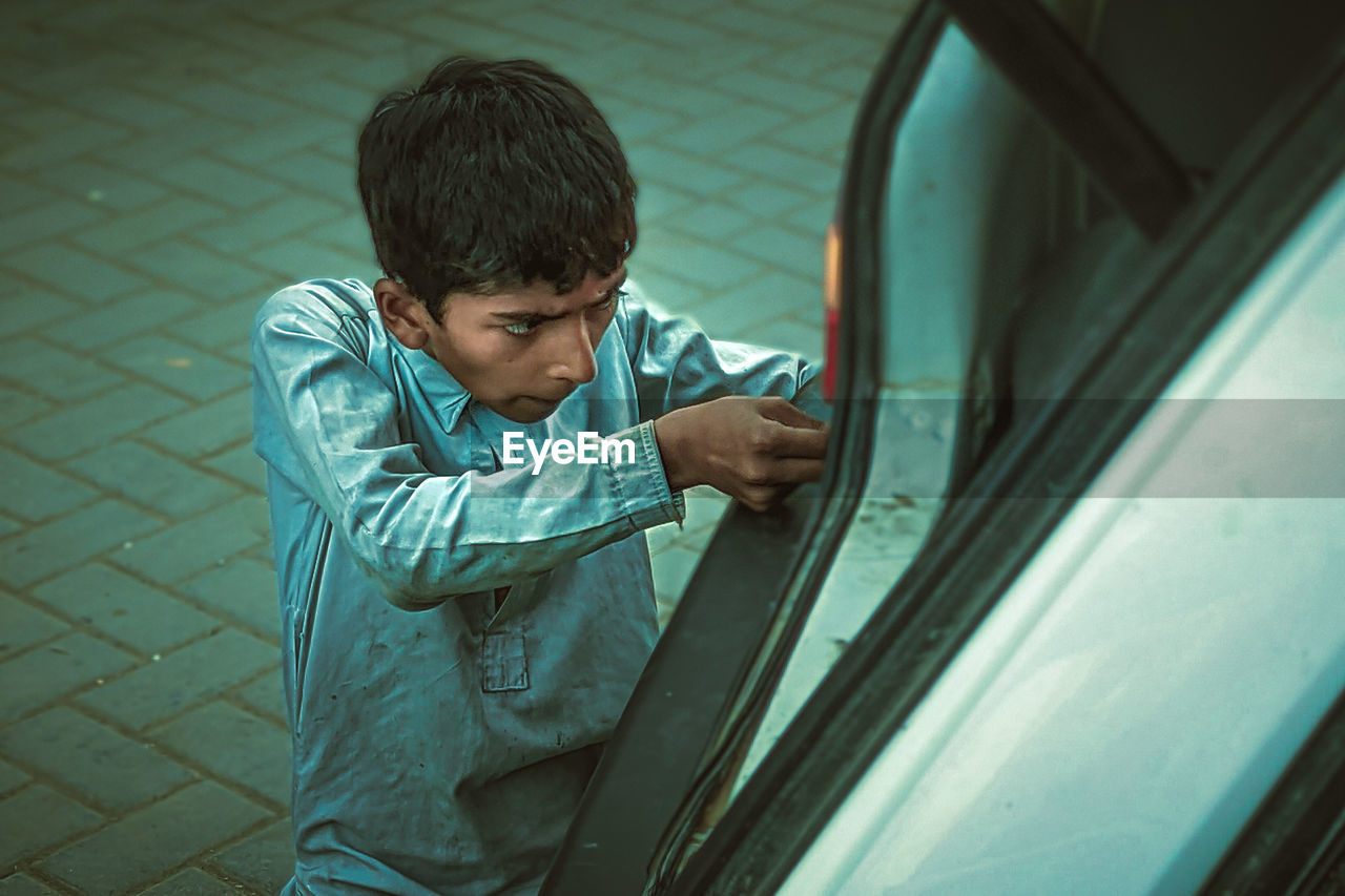 Boy repairing car outdoors