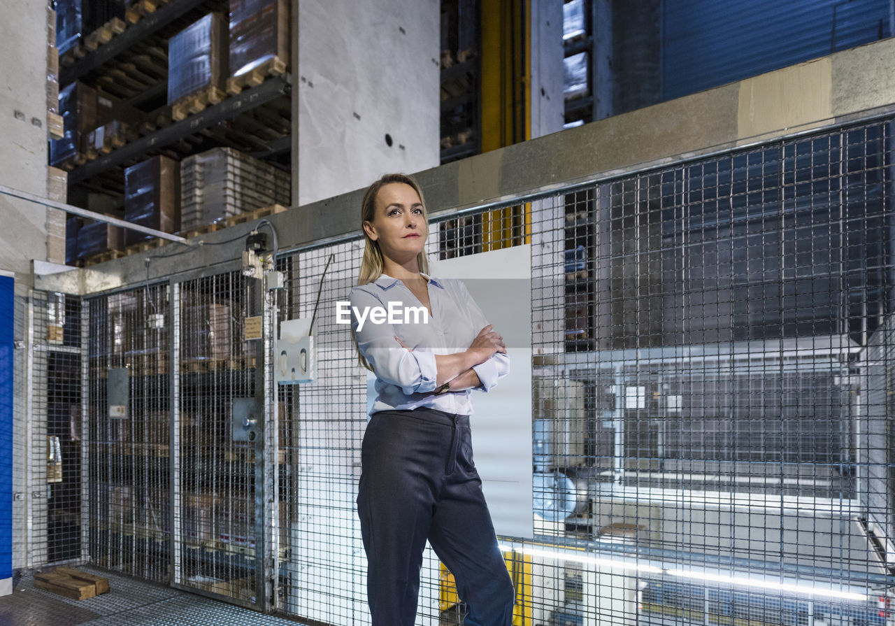 Blond woman in high rack warehouse