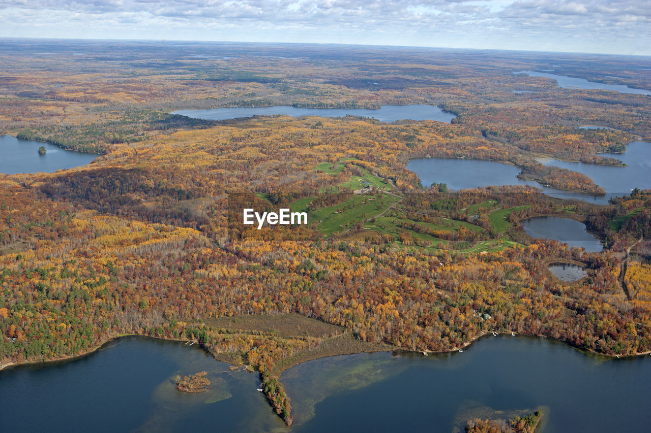 AERIAL VIEW OF LAKE AMIDST LANDSCAPE AGAINST SKY