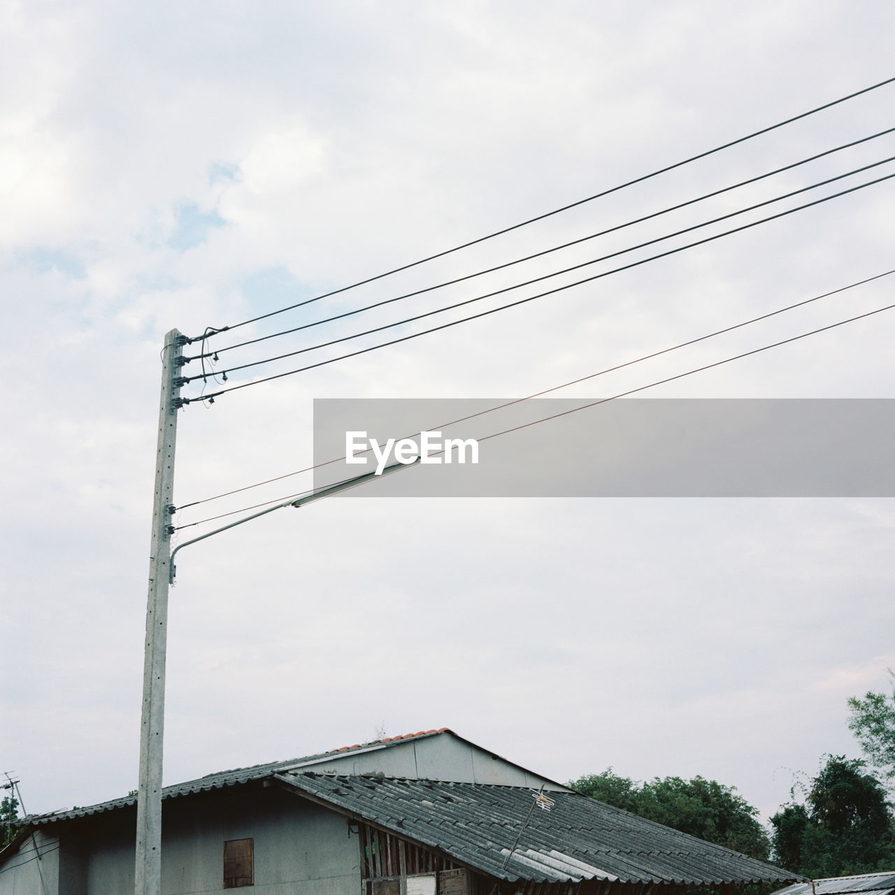 LOW ANGLE VIEW OF CABLES AGAINST SKY AND BUILDING