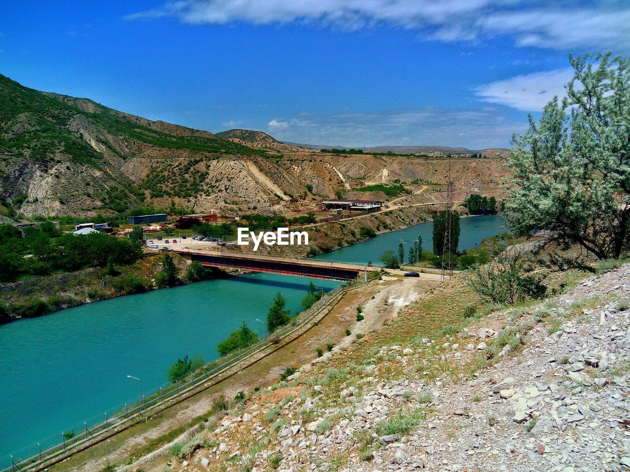 Scenic view of river by mountains against sky