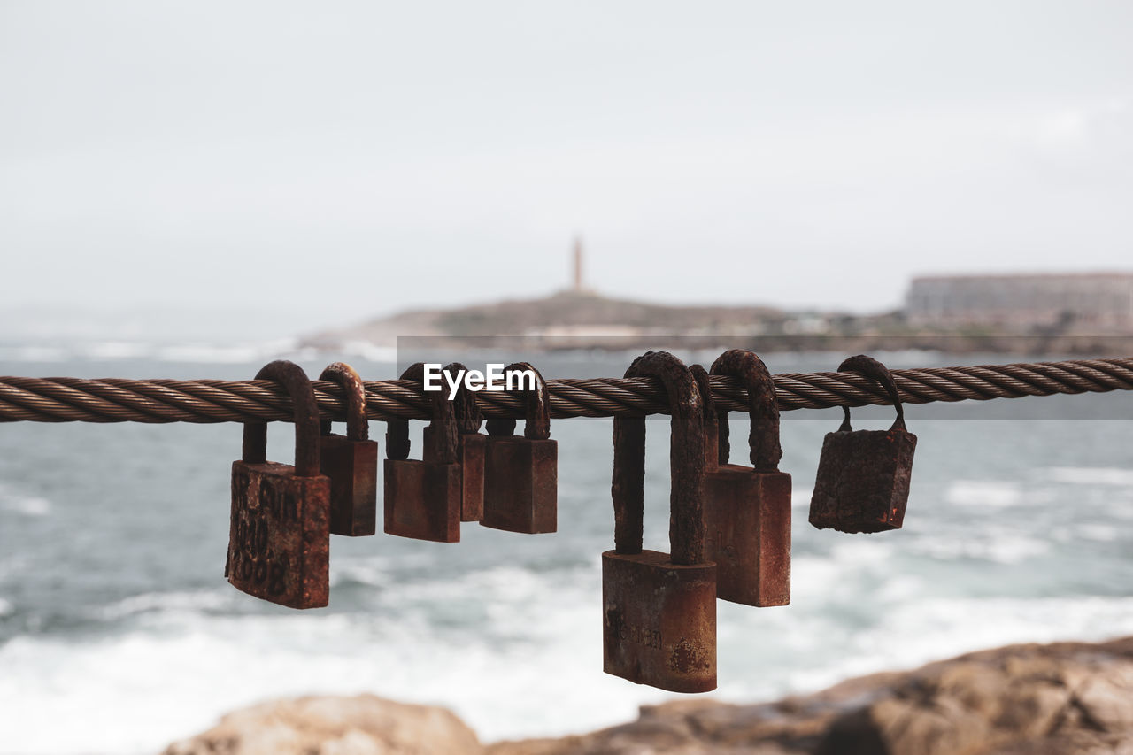 padlock, lock, security, protection, hanging, love lock, hope, love, metal, water, positive emotion, sky, focus on foreground, nature, emotion, travel destinations, railing, architecture, day, bridge, trust, river, no people, iron, luck, built structure, outdoors, wood, rusty, fence, tourism, travel, tradition, cloud, close-up, large group of objects, aspirations, winter