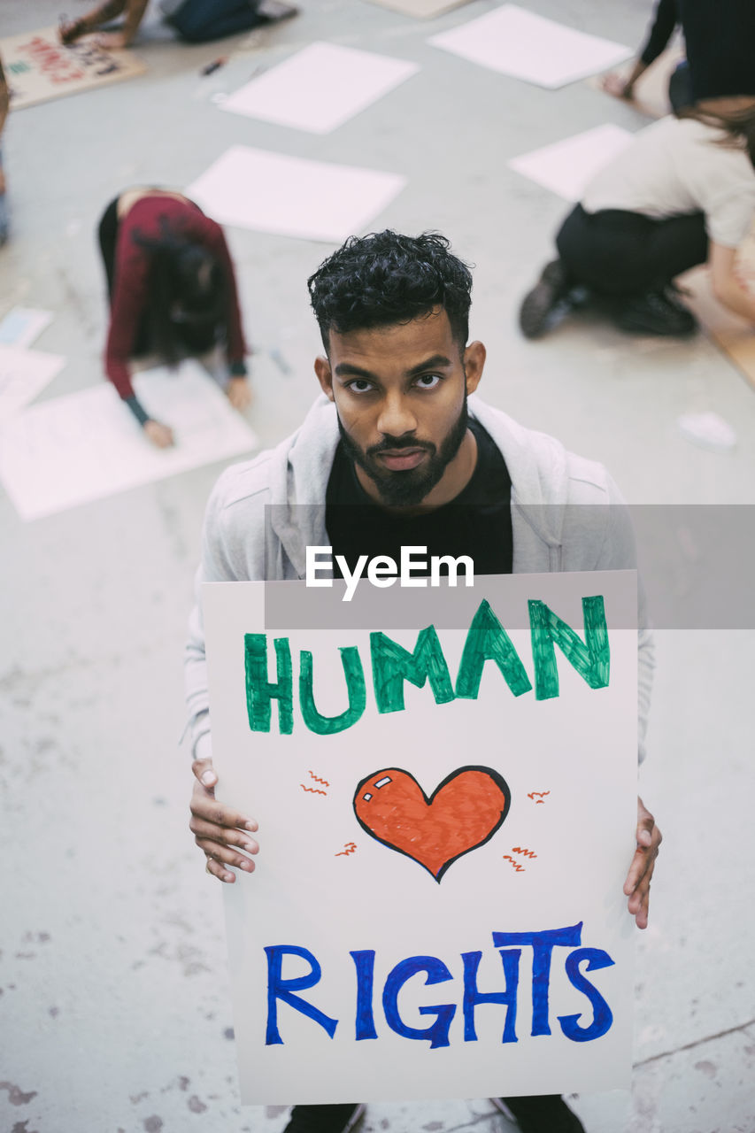 Male activist holding human rights poster during social issues