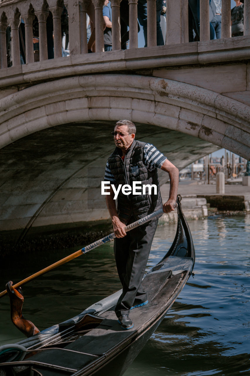 FULL LENGTH OF MAN STANDING ON BOAT