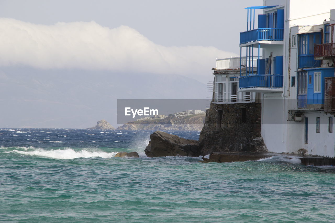 View of buildings by sea against sky