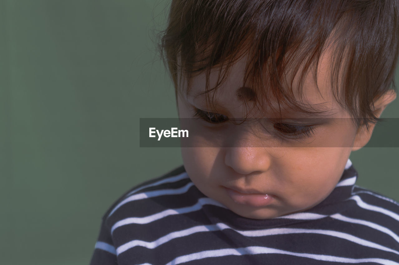 child, childhood, one person, portrait, human face, person, striped, headshot, sadness, men, nose, human eye, human head, toddler, hairstyle, innocence, emotion, indoors, close-up, cute, human hair, facial expression, casual clothing, portrait photography, studio shot, negative emotion, front view, looking, skin, displeased, human mouth, teardrop, brown hair, crying, disappointment, baby, depression - sadness, sulking, serious, distraught