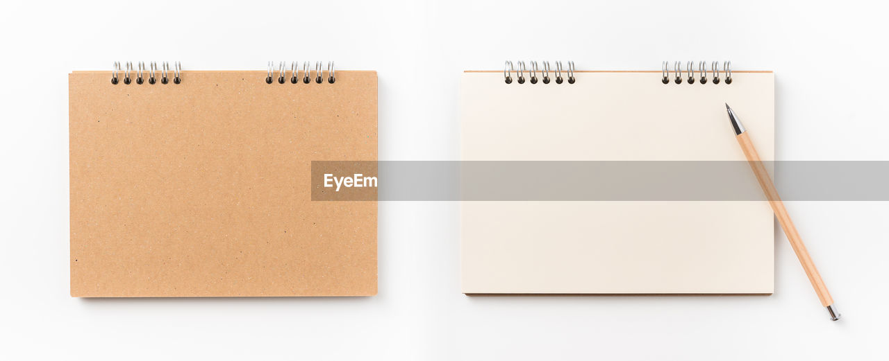 Directly above shot of spiral notebooks against white background