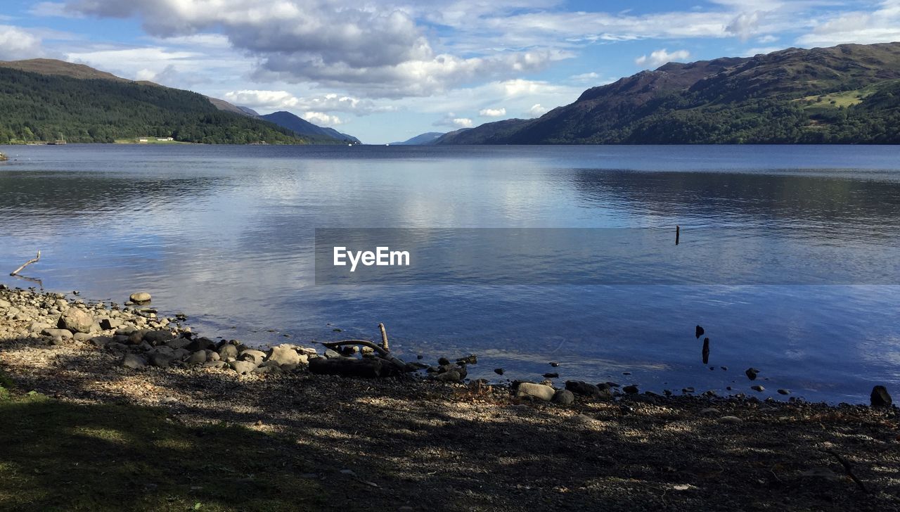 Calm lake with mountains in background