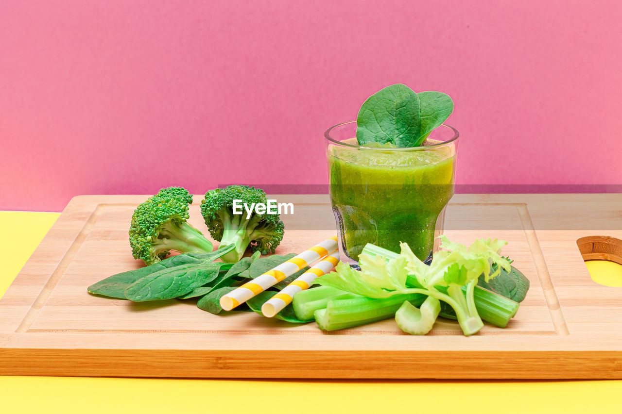 food and drink, food, healthy eating, vegetable, wellbeing, freshness, green, indoors, broccoli, studio shot, smoothie, herb, fruit, household equipment, cutting board, raw food, spinach, produce, no people, drink, glass, celery, drinking glass, refreshment, organic, ingredient, kale, still life, spice, vegetarian food, colored background, detox, cucumber, wood, leaf vegetable, root vegetable, lettuce, leaf, cabbage, carrot, antioxidant, vitamin