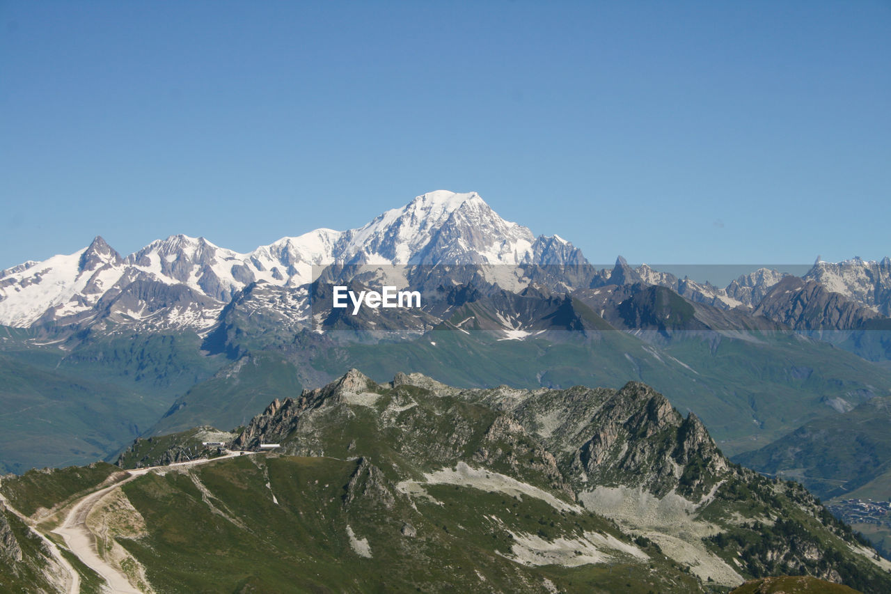 Scenic view of snowcapped mountains against clear blue sky