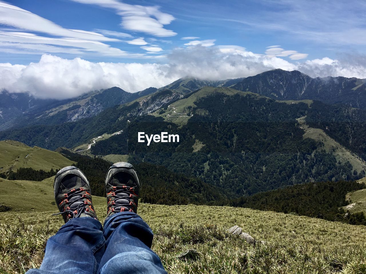 Low section of man on mountain against sky