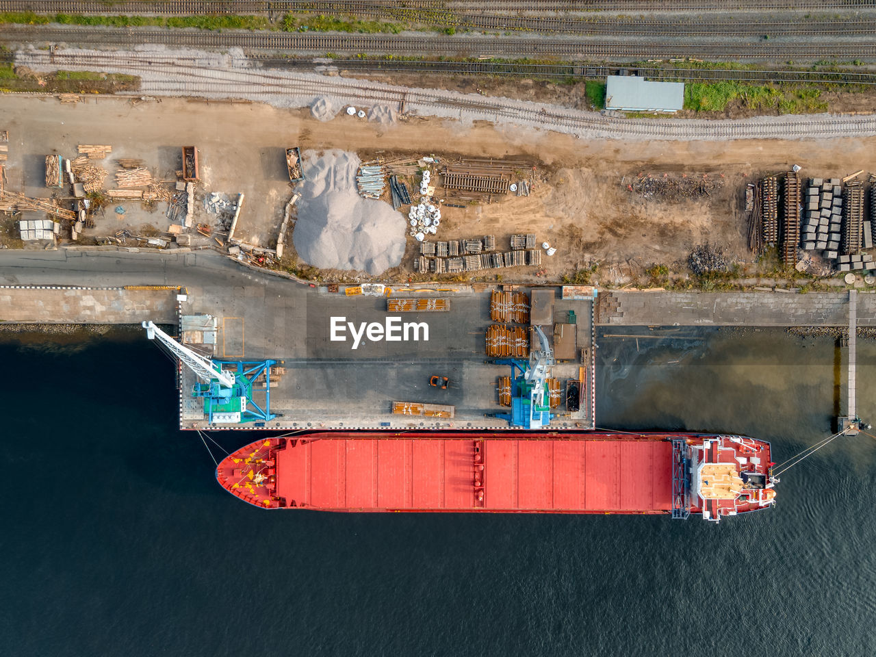 Port cranes load various cargoes or building materials into the hold of the ship. 