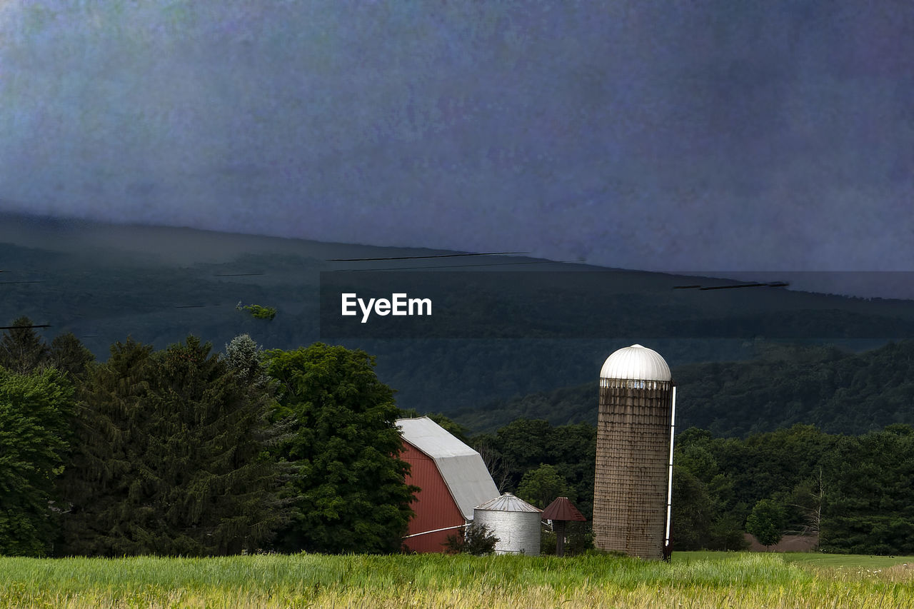 Silos in a field as storm clouds come in