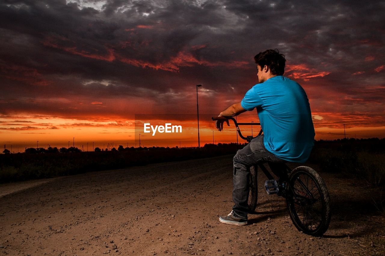 Man standing on landscape at sunset