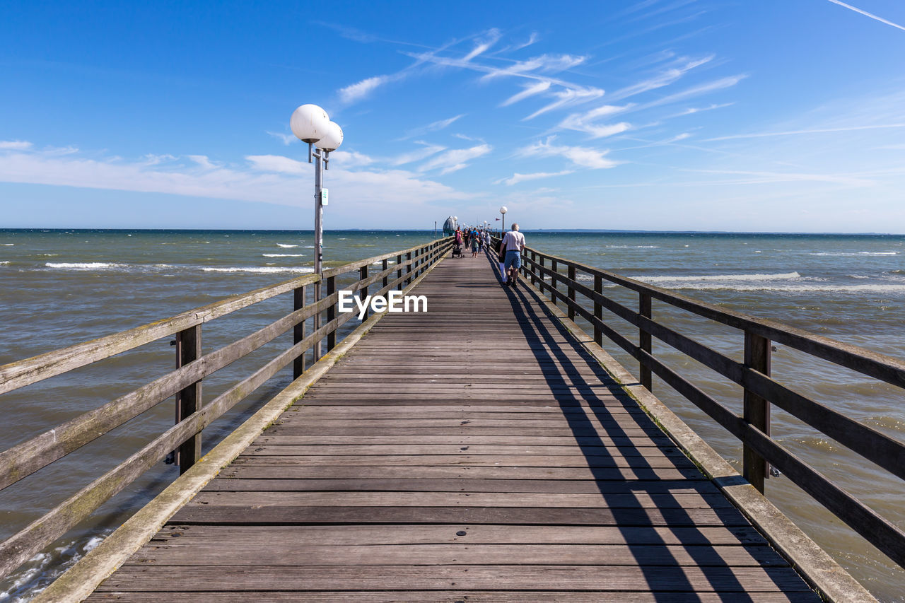 WOODEN PIER ON SEA AGAINST SKY