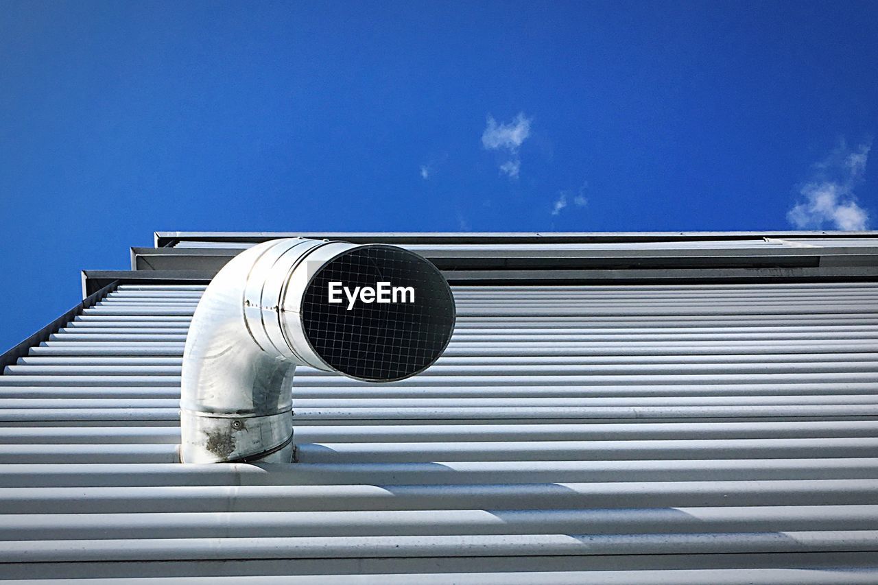 Low angle view of pipe on building against sky