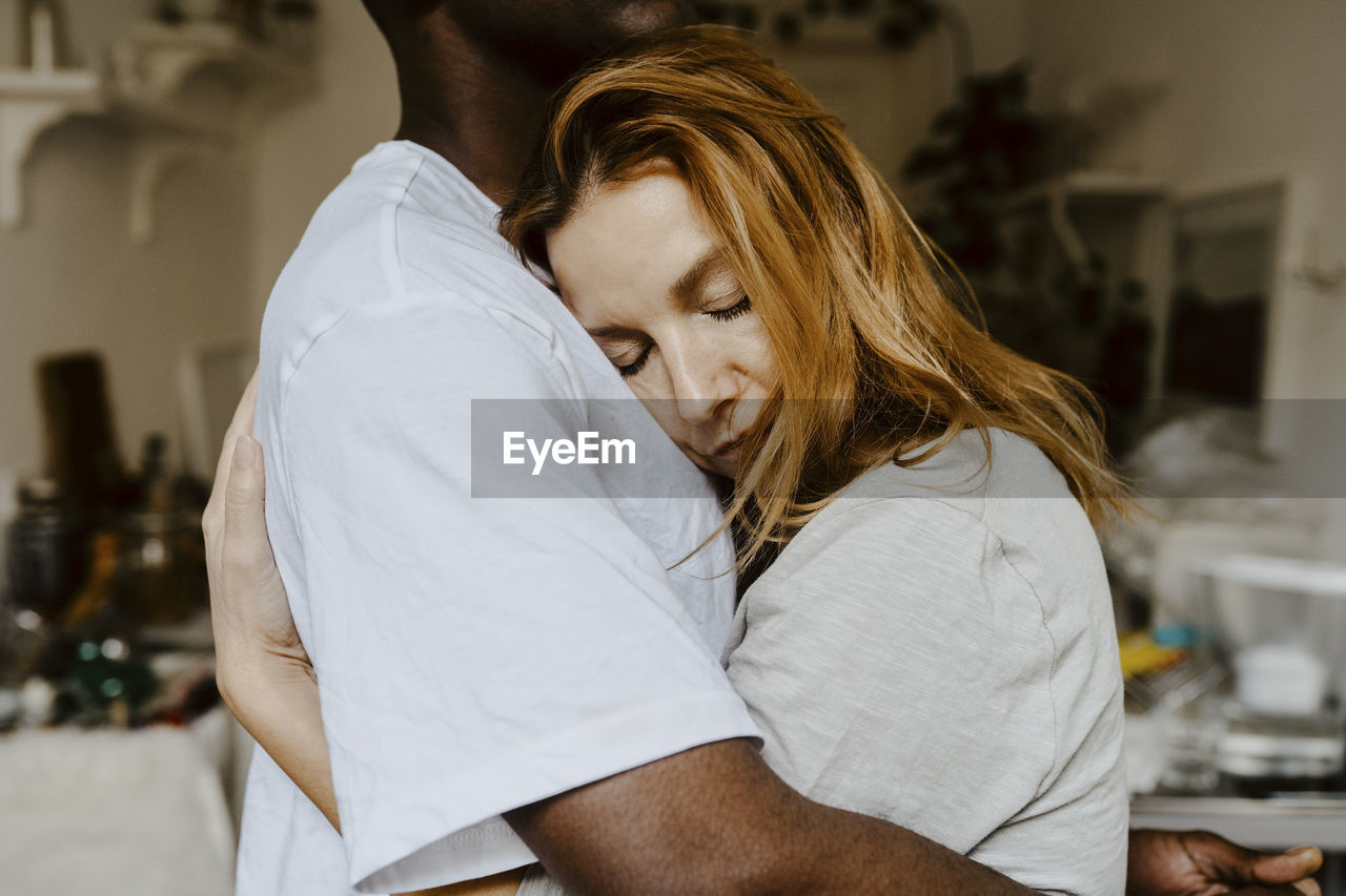 Son and mother embracing each other at home