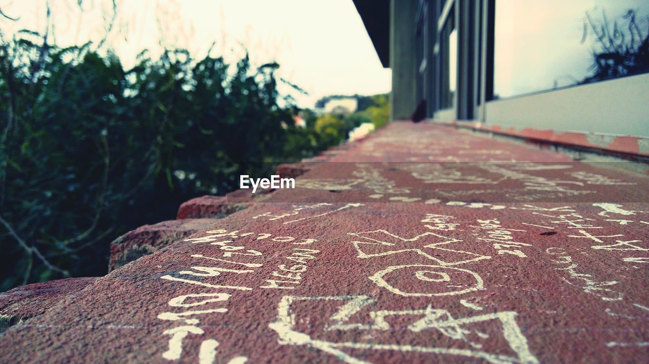 Close-up of chalk drawings on retaining wall