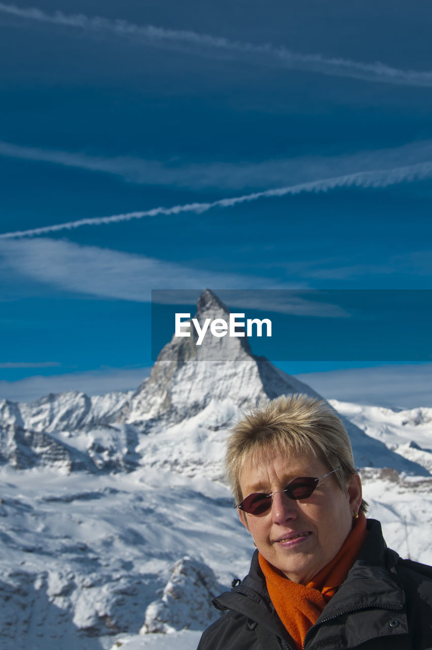 Portrait of mature woman against snowcapped mountain