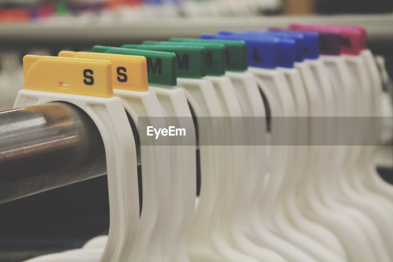 Close-up of coat hangers hanging on rod in store