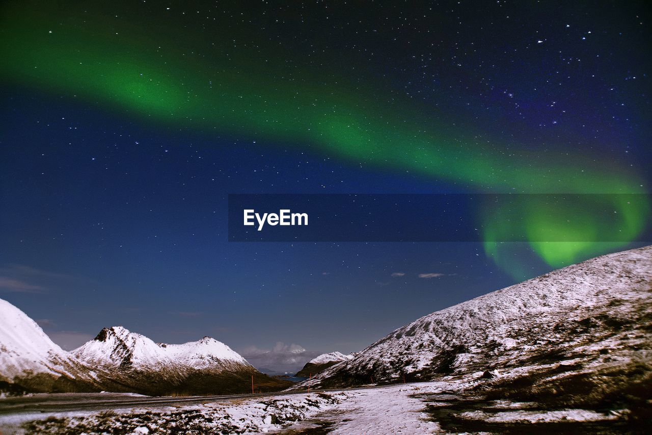 Scenic view of snowcapped mountains against sky at night