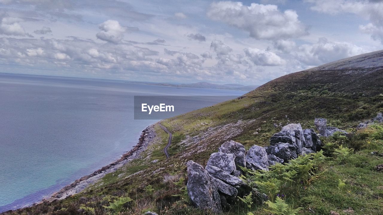 Scenic view of sea and mountains against sky