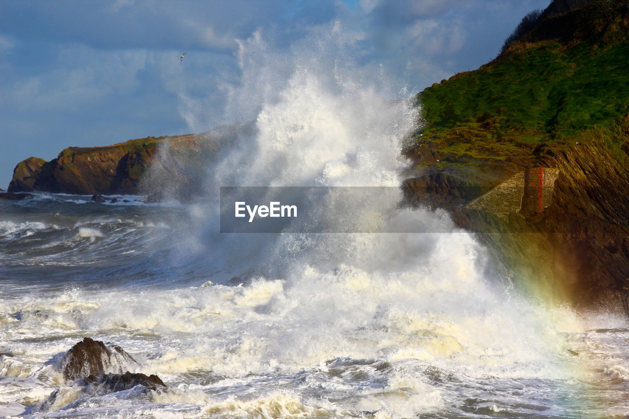 Waves splashing on sea against sky