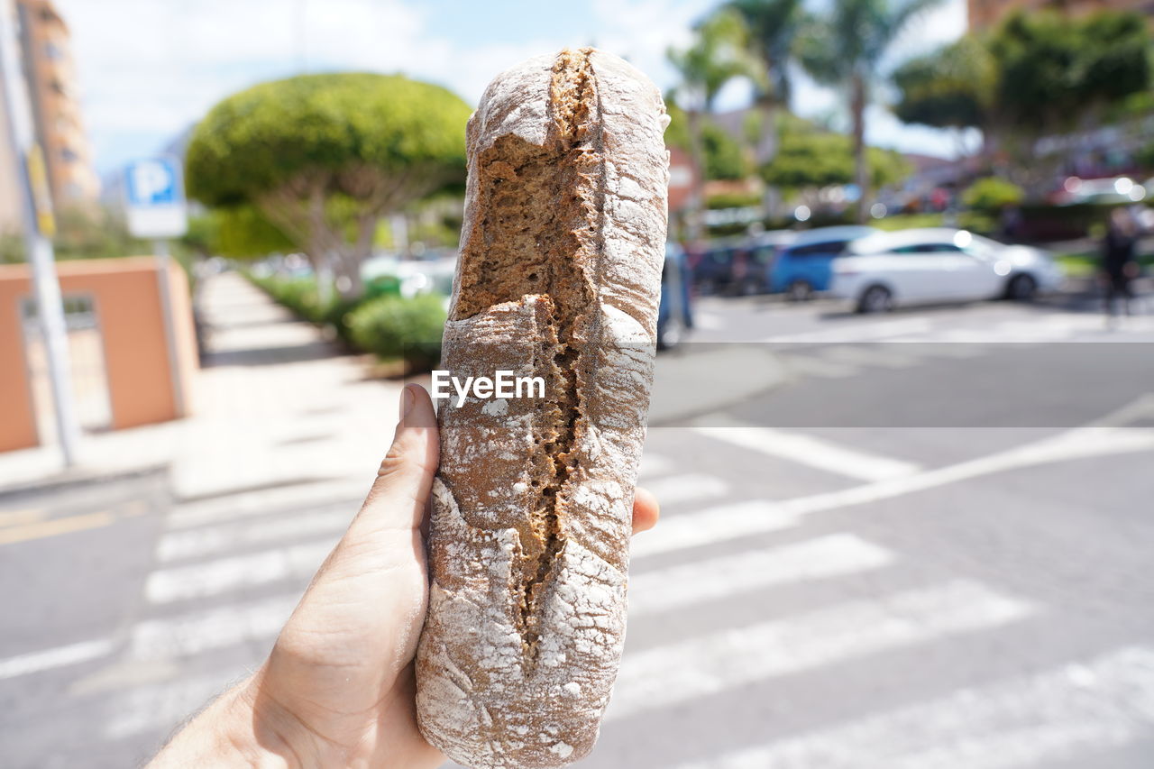 CLOSE-UP OF HAND HOLDING ICE CREAM