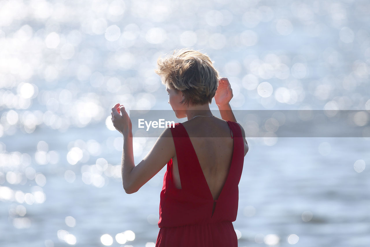 Rear view of woman standing against sea