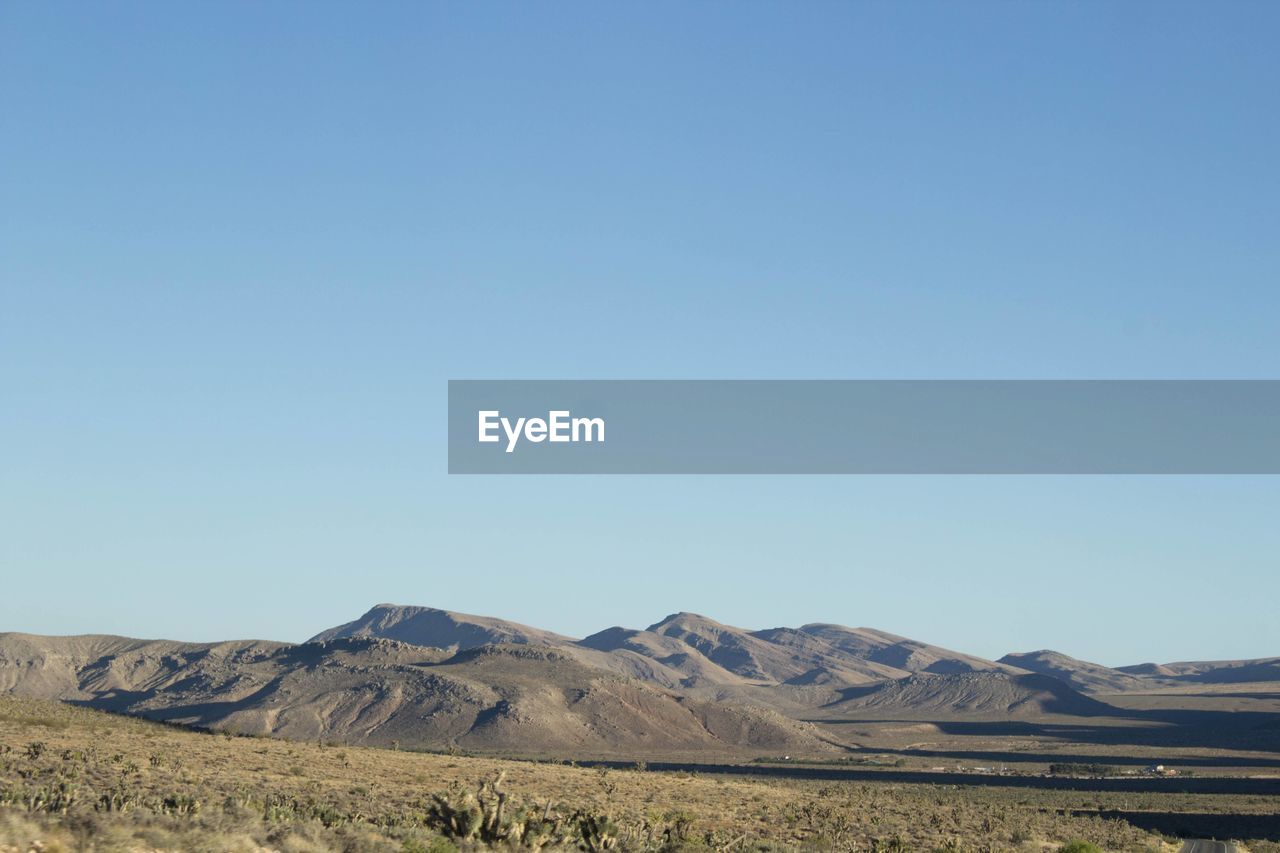 landscape, environment, sky, scenics - nature, horizon, natural environment, mountain, land, nature, plain, beauty in nature, blue, copy space, clear sky, no people, steppe, non-urban scene, wilderness, desert, tranquil scene, day, plateau, prairie, tranquility, grassland, mountain range, semi-arid, sunny, field, outdoors, plant, valley, remote, travel destinations, arid climate, geology, climate, travel, grass, physical geography