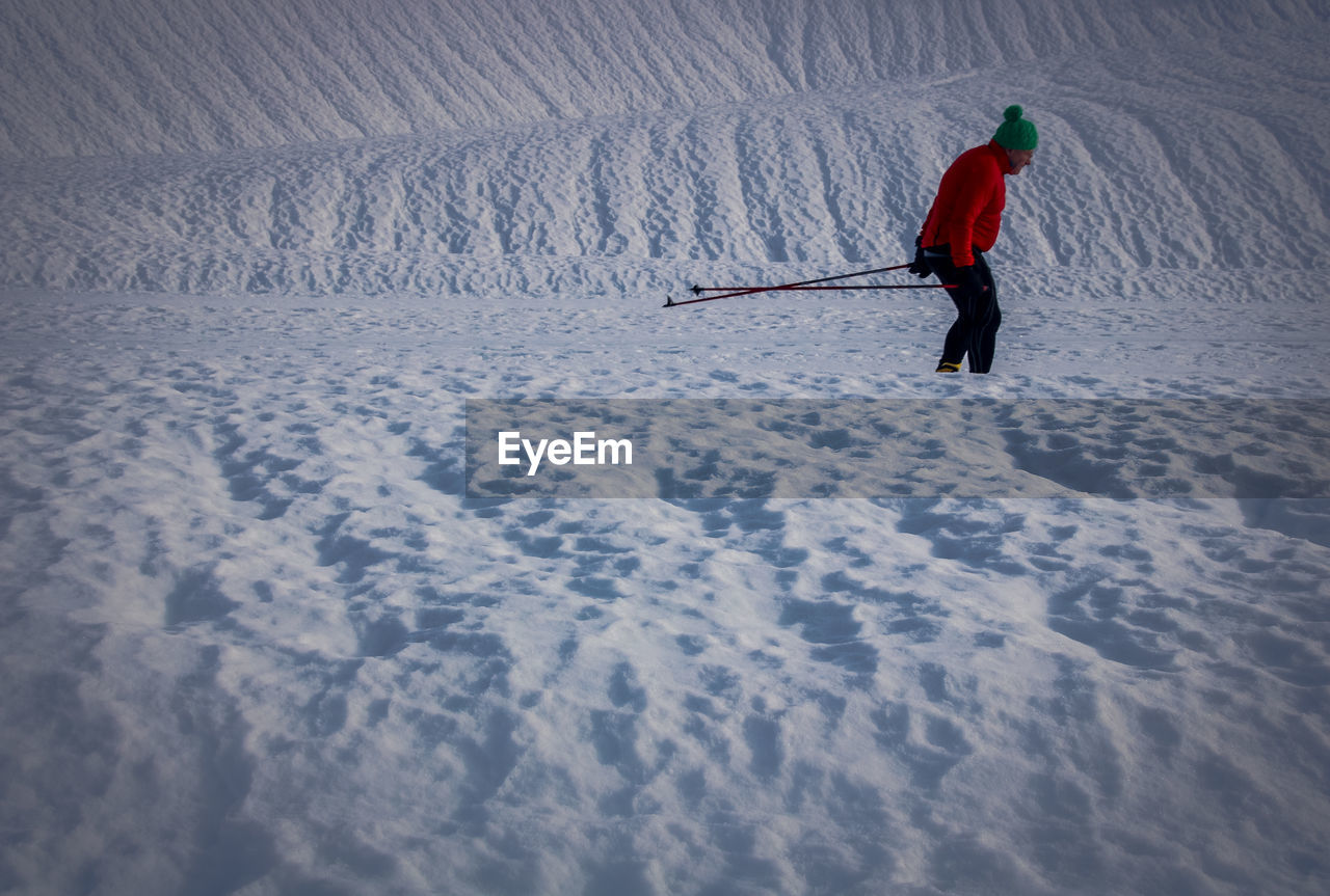 Side view of mature man skiing on snowcapped mountain