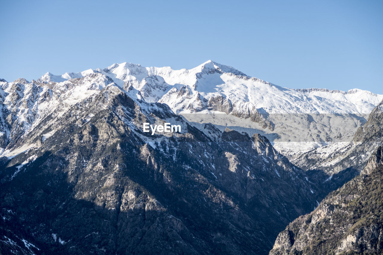 Scenic view of snowcapped mountains against clear sky