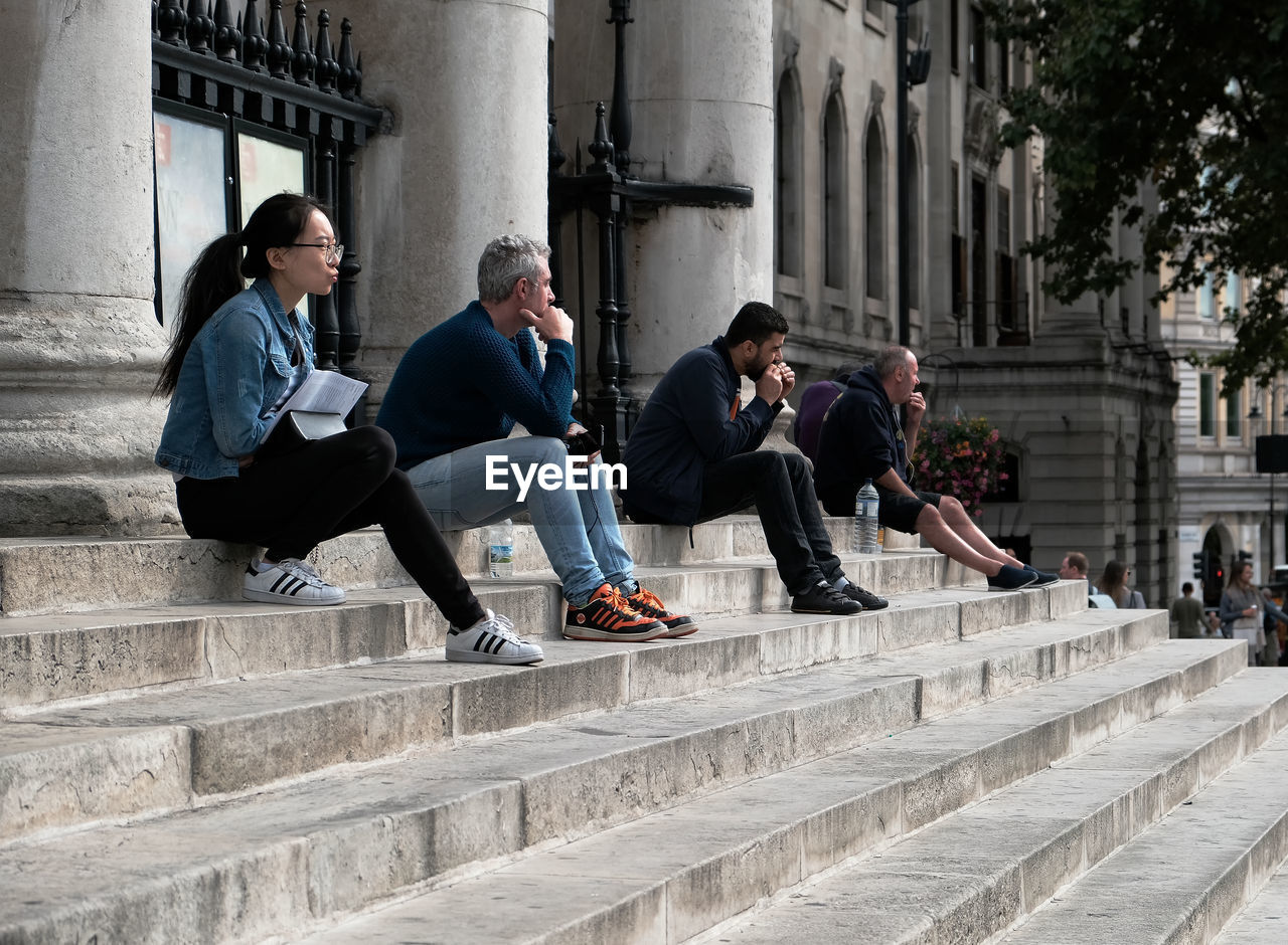 PEOPLE ON STAIRCASE AGAINST BUILDINGS