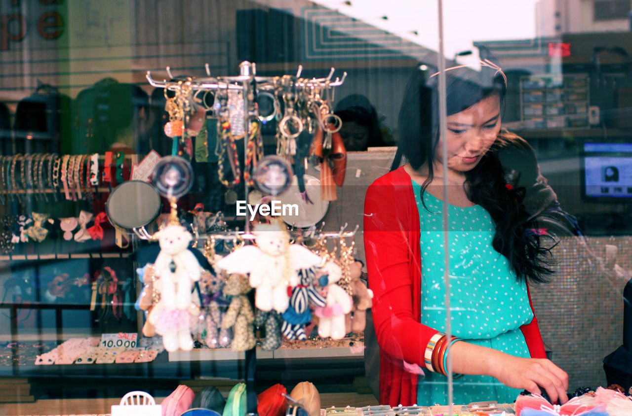 Woman shopping while seen through window glass of store