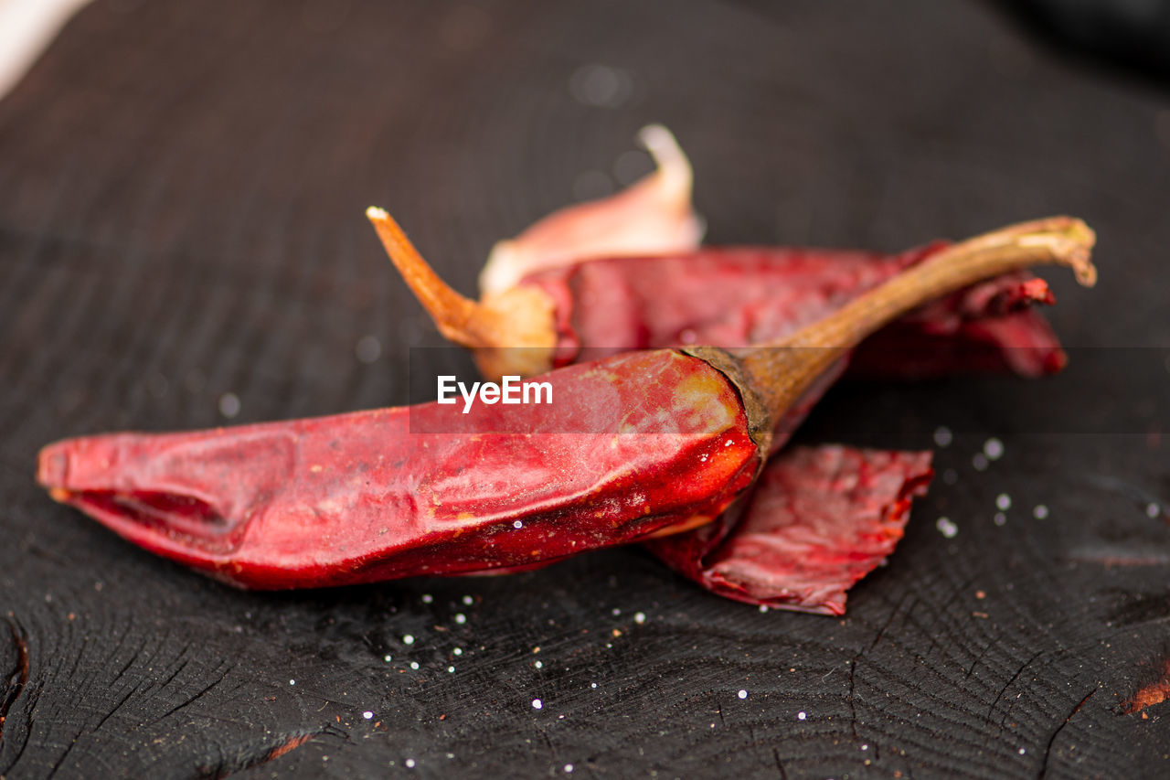 Hot chili peppers on a wooden rustic black board in a street food market, close up