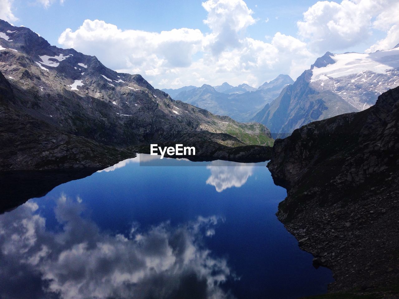 Scenic view of lake by mountains against sky