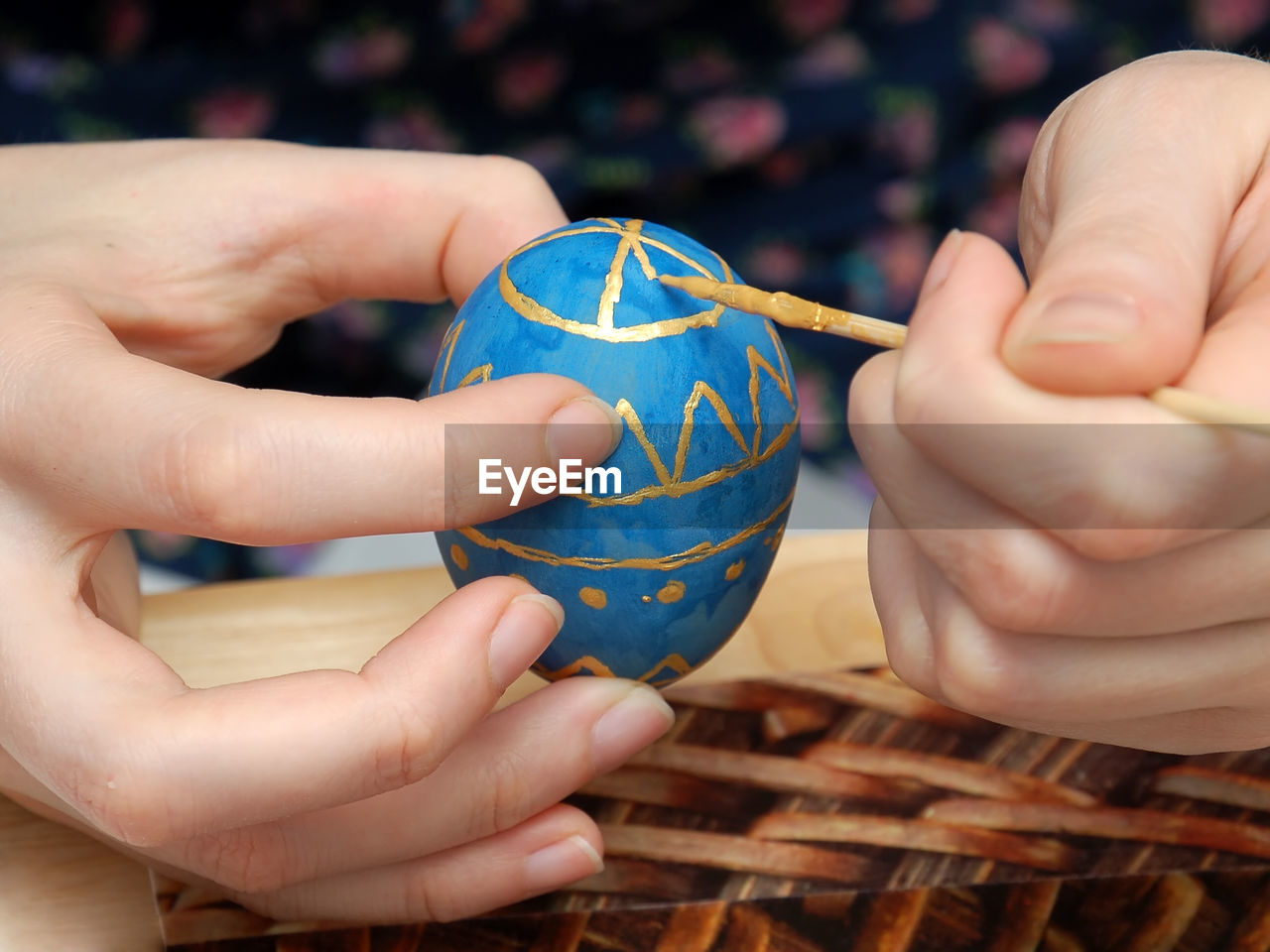 Cropped hand of woman painting egg