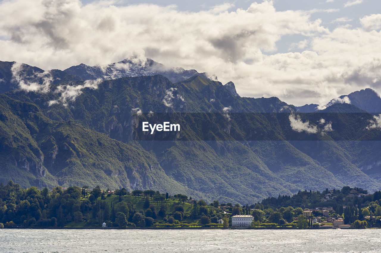 Scenic view of lake by mountains against sky