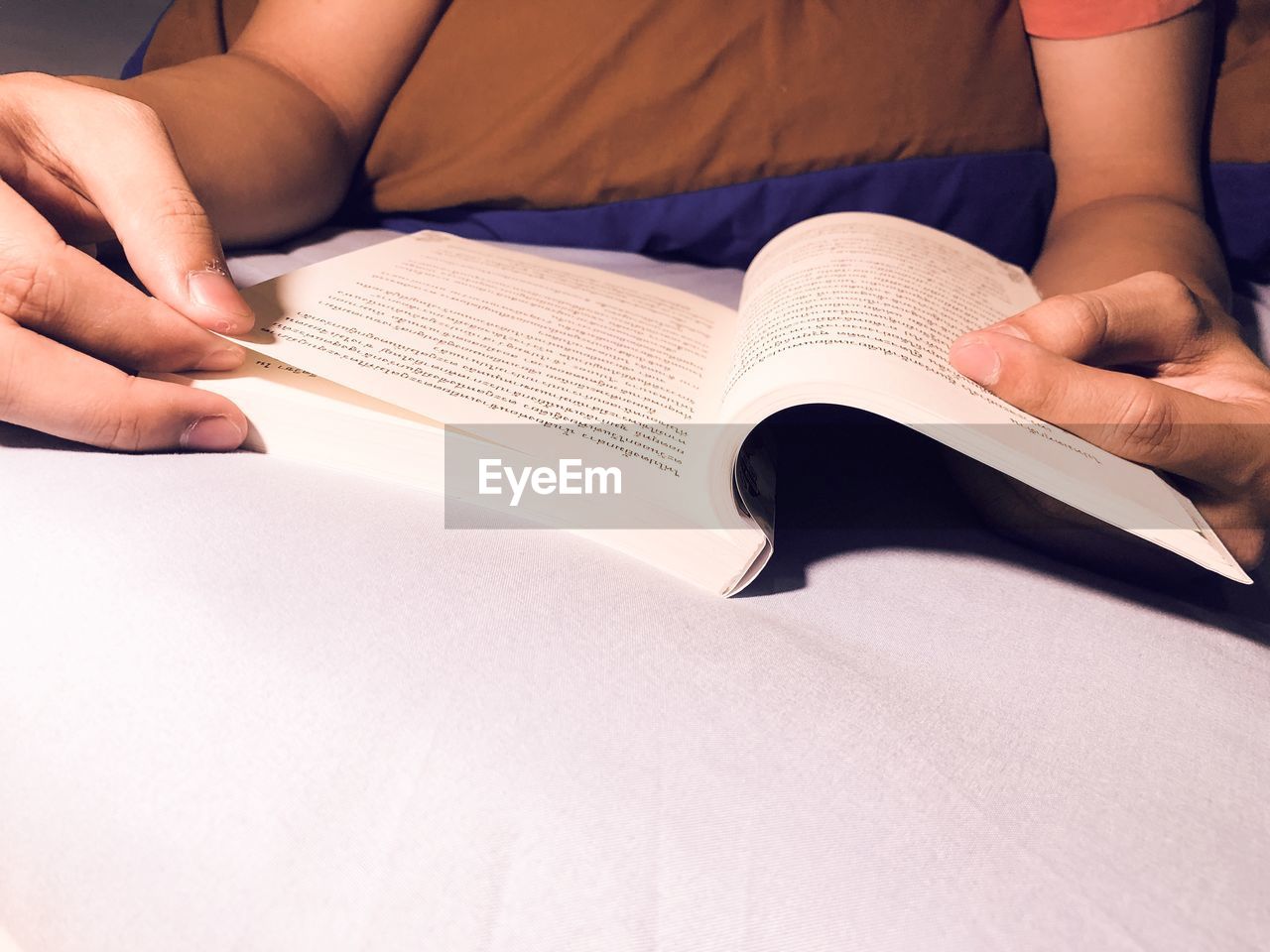 LOW SECTION OF PERSON ON BOOK